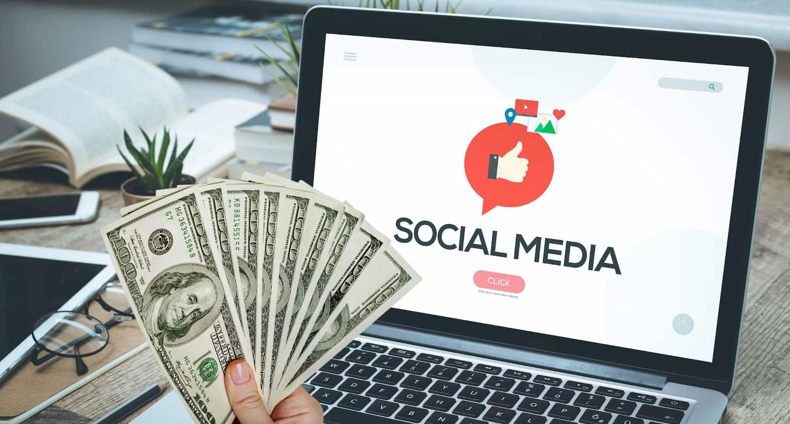Social media on the laptop screen and a hand holding cash