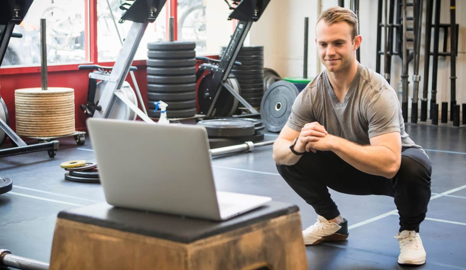 A man in front of the laptop in the gym