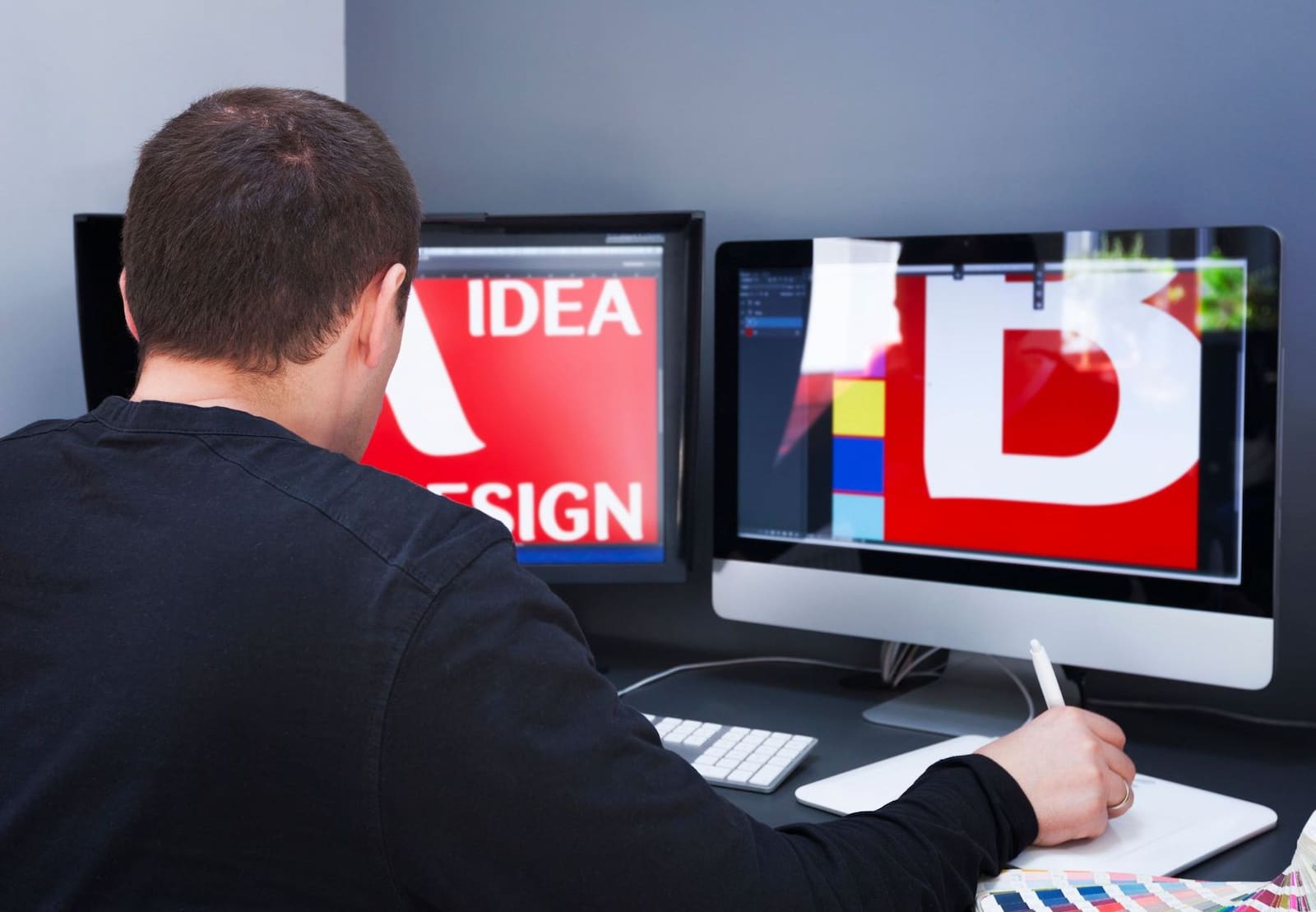 A man working on design in front of two monitors